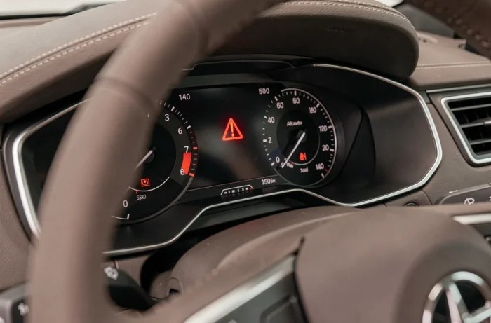 Tableau de bord de voiture avec le voyant triangle rouge point d'exclamation allumé